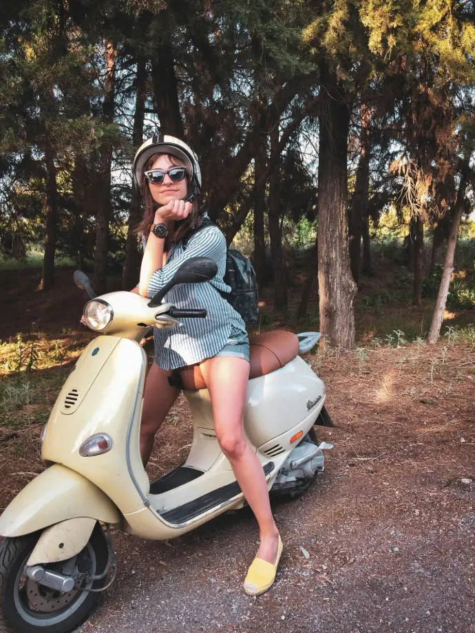 Woman relaxing on a Vespa in nature